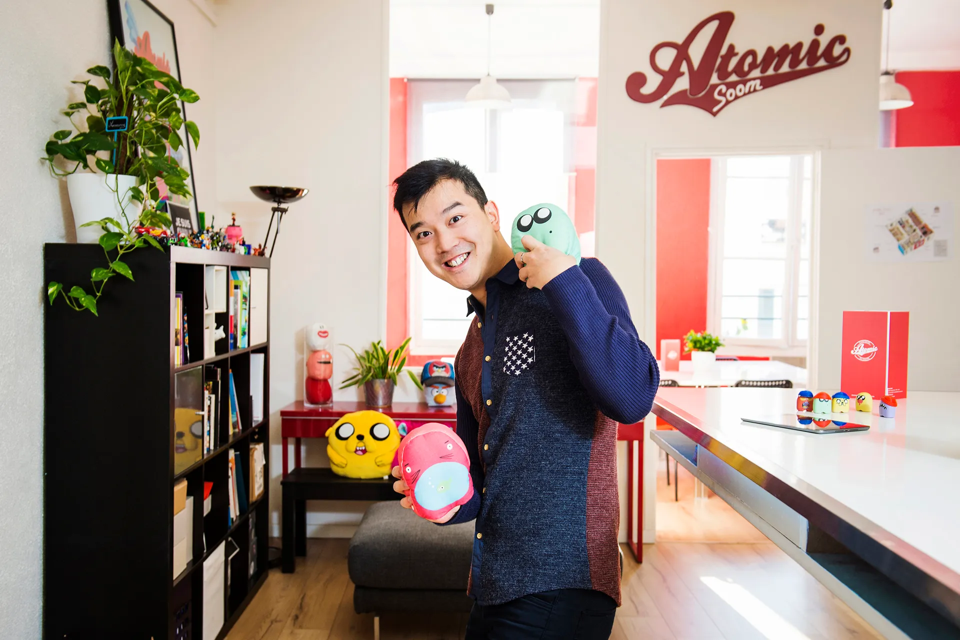 portrait d'un homme qui tient des peluches dans les locaux d'une startup