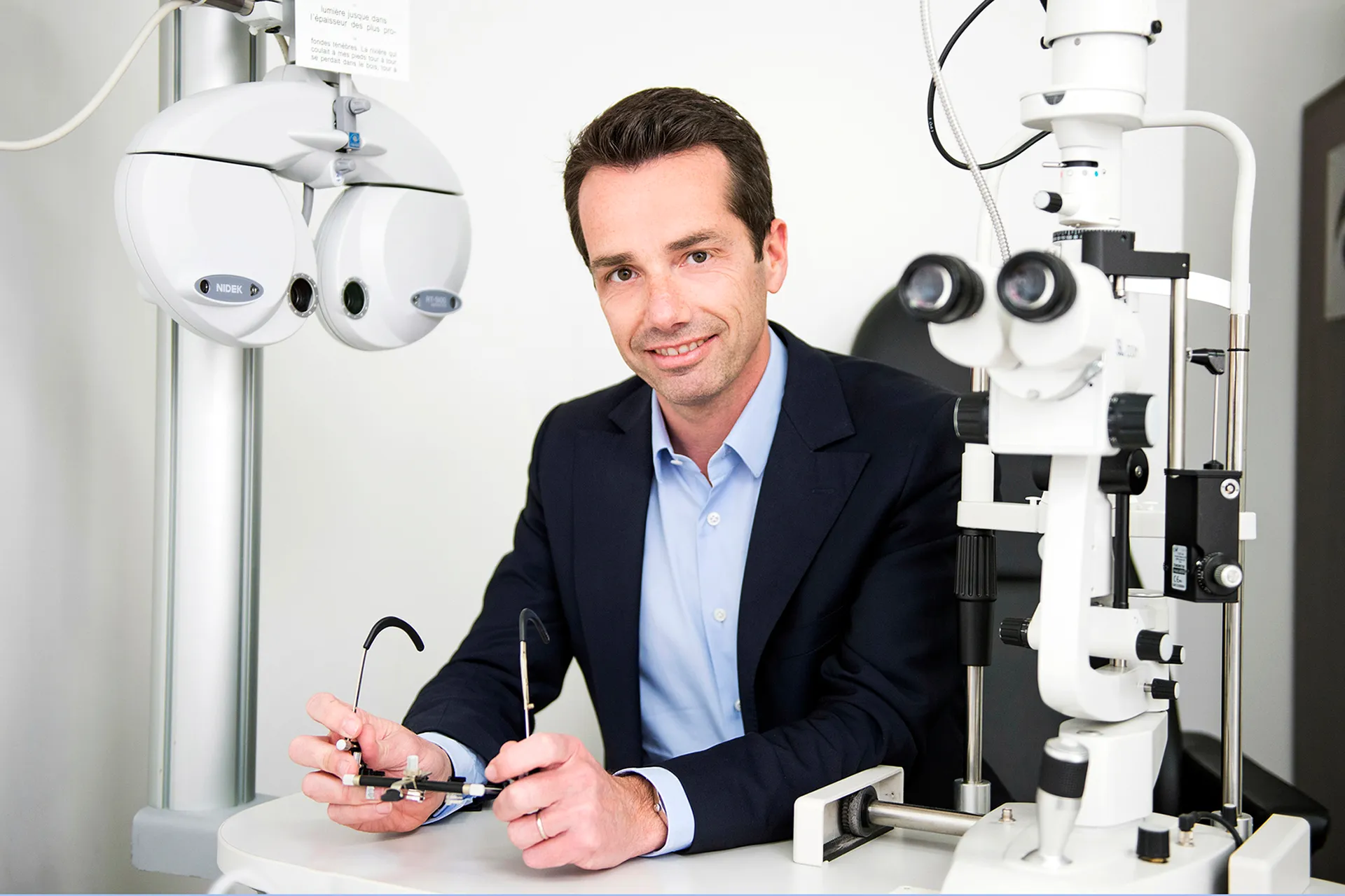 portrait d'un homme travaillant sur une paire de lunettes dans un laboratoire