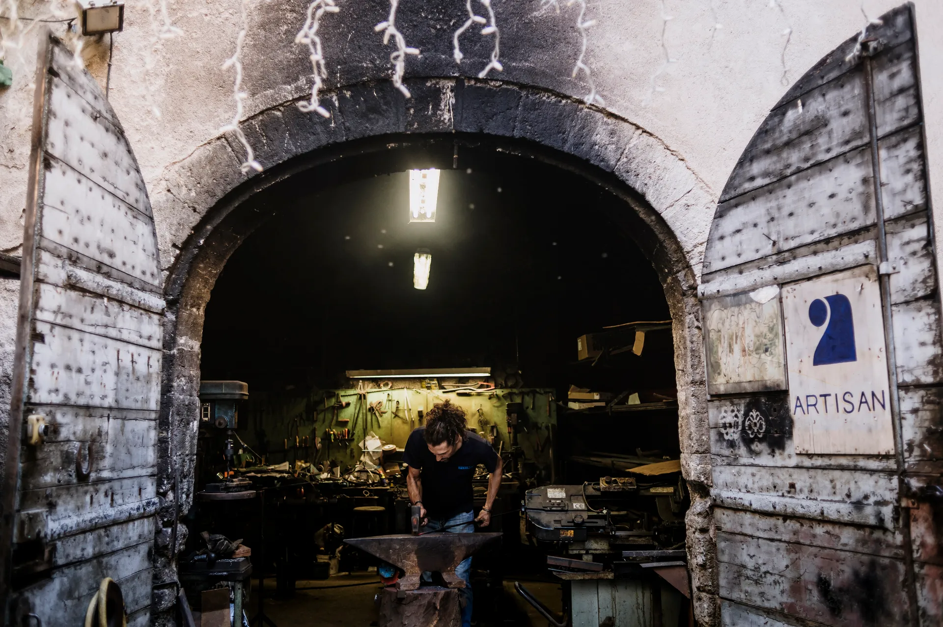 le forgeron au travail dans son atelier ouvert sur la rue