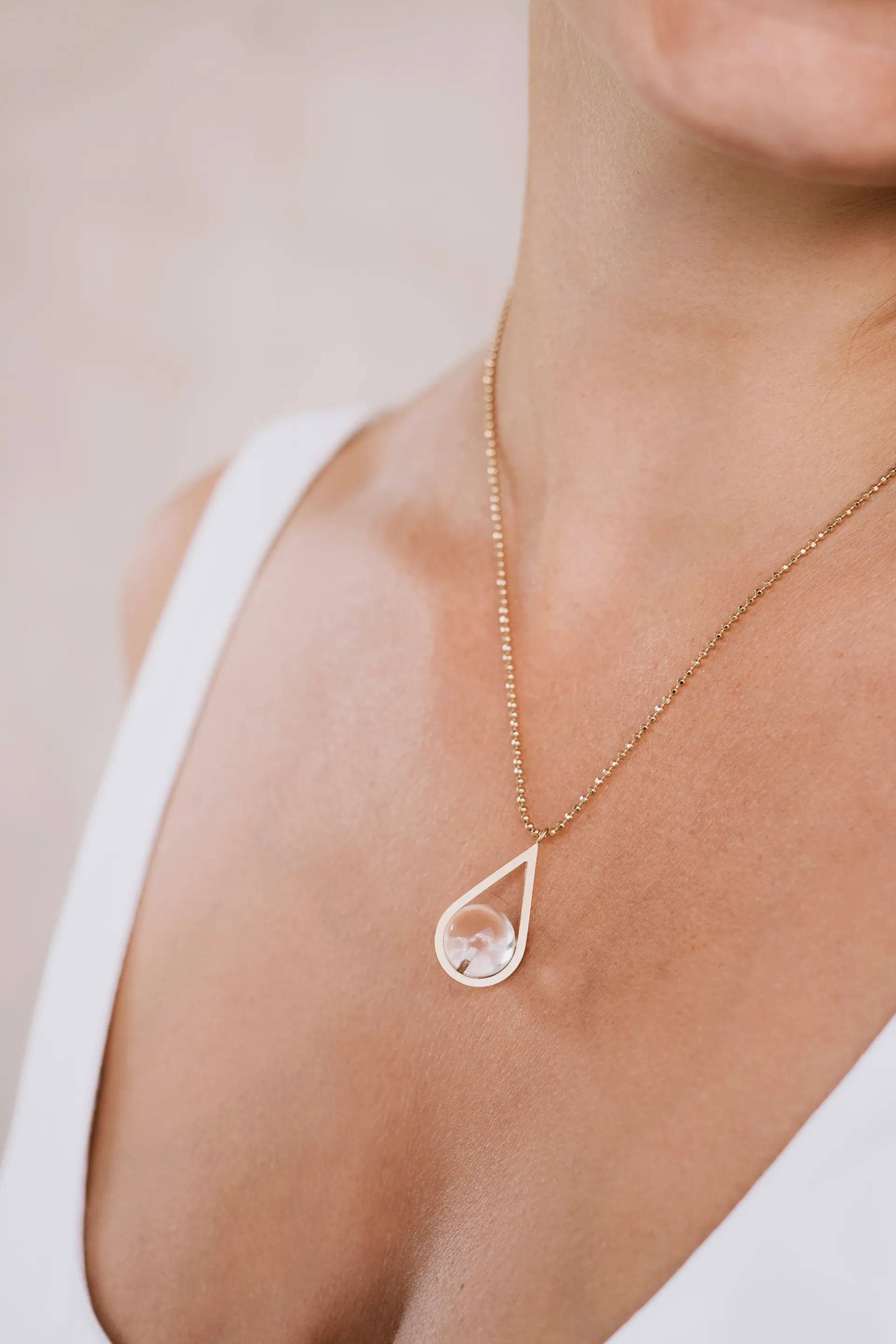 collier au cou d'un femme en robe blanche