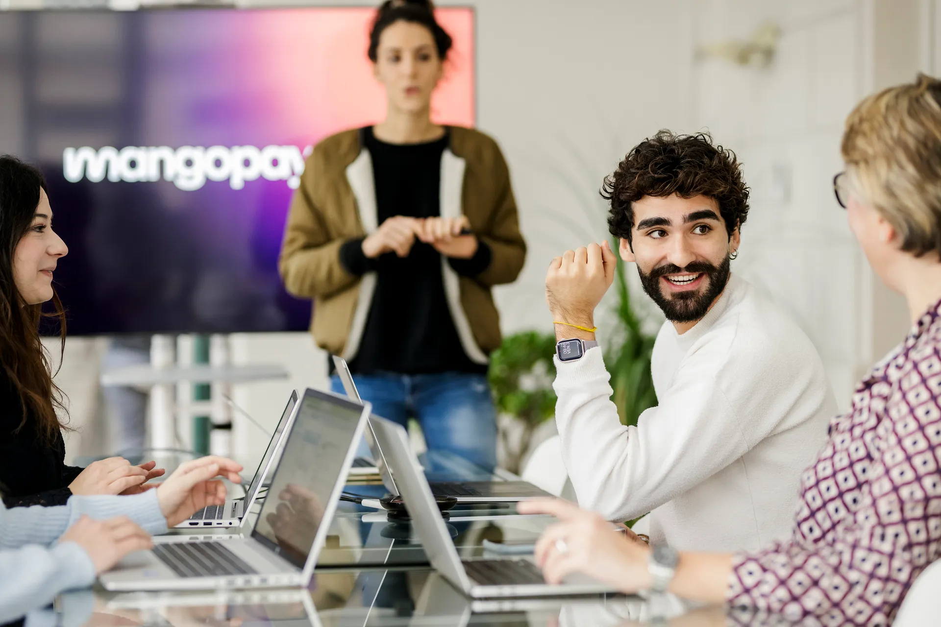 portrait d'une collaboratrice à son bureau, souraint à un collègue