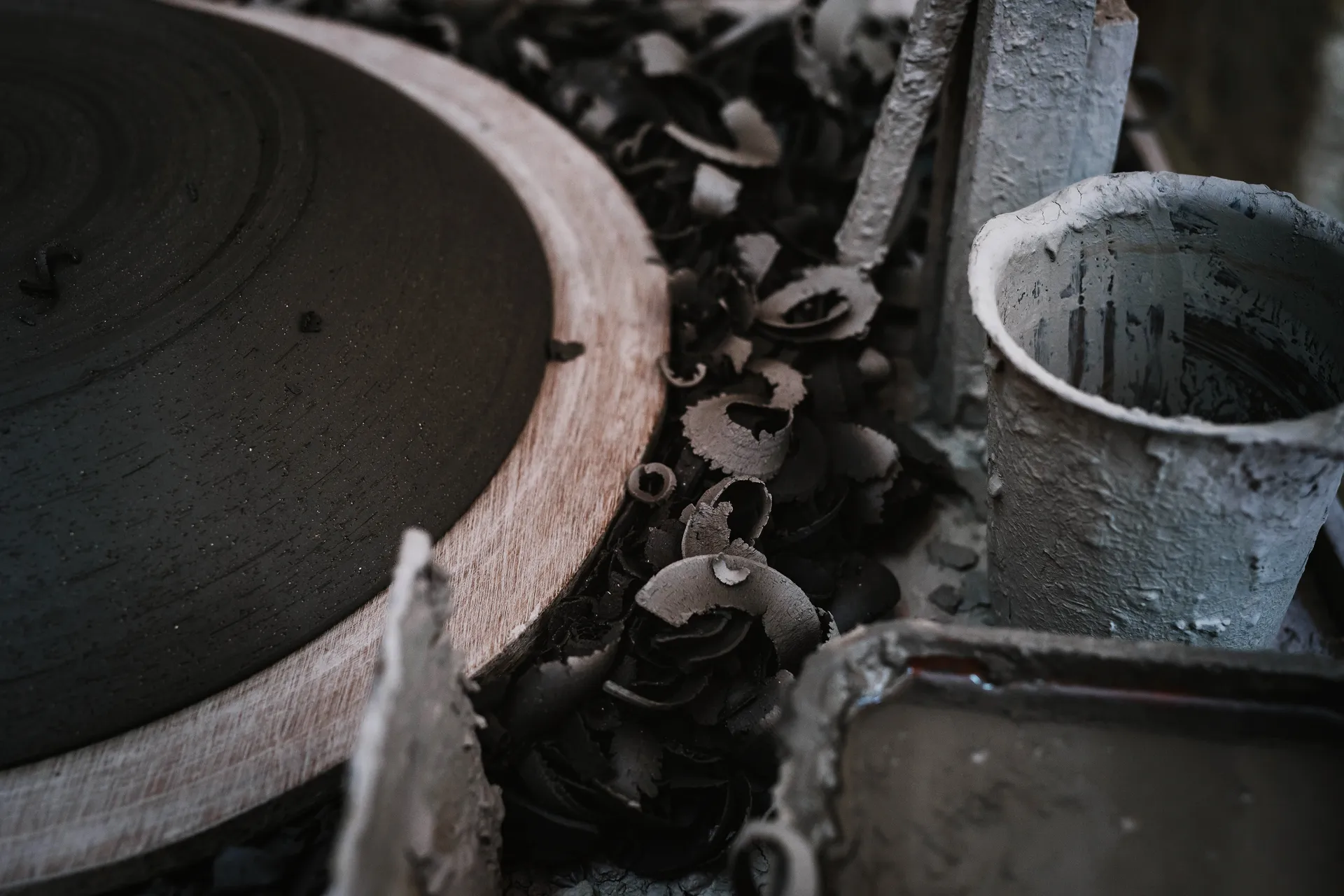 gros plan sur des chutes d'argile au pied du tour de poterie