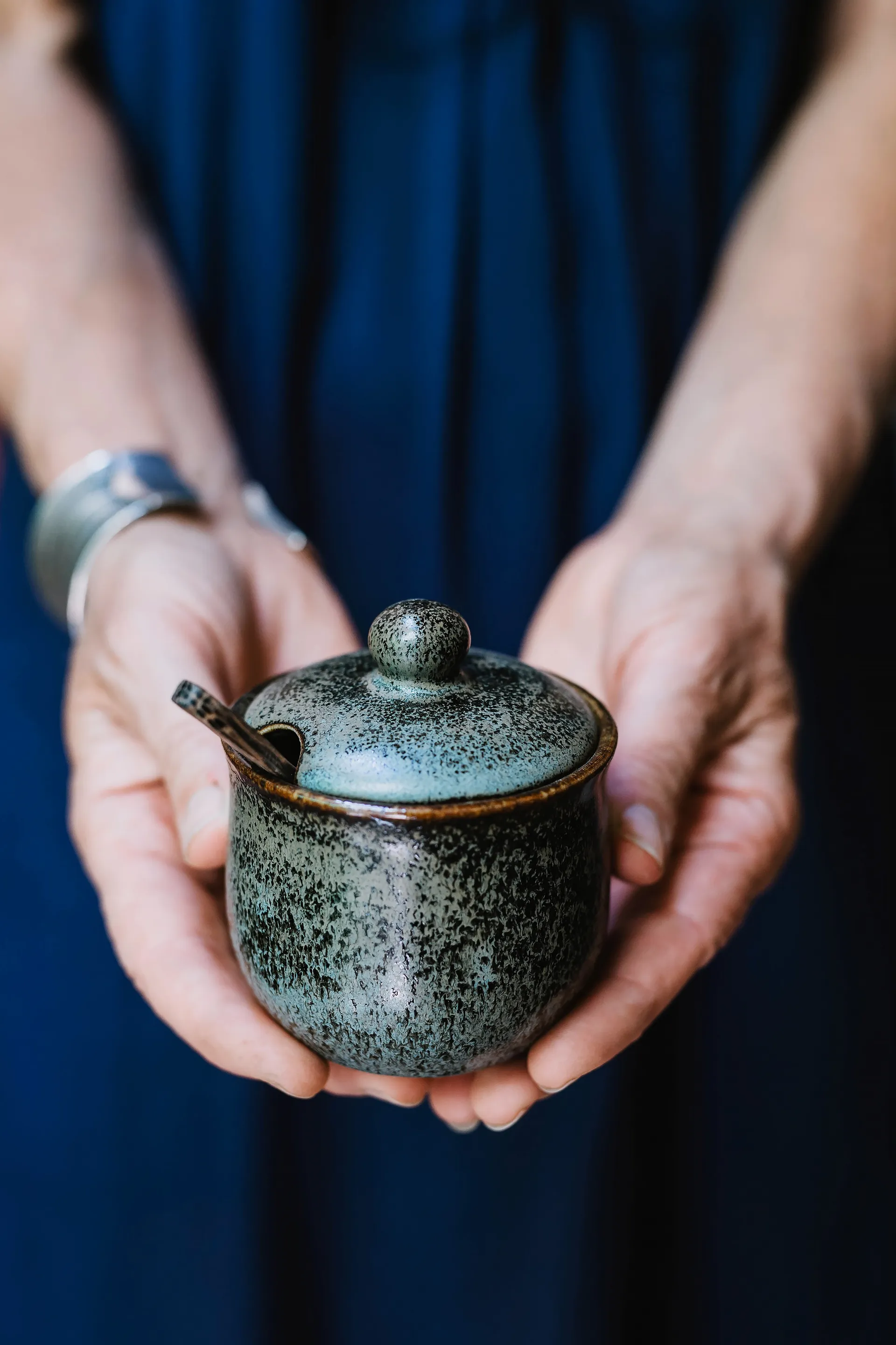 gros plan sur les mains de la céramiste présentant un petit pot