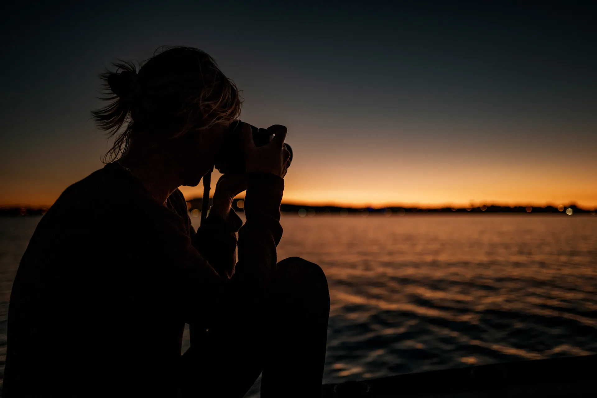 une silhouette photographie le lever de soleil sur l'étang de Thau