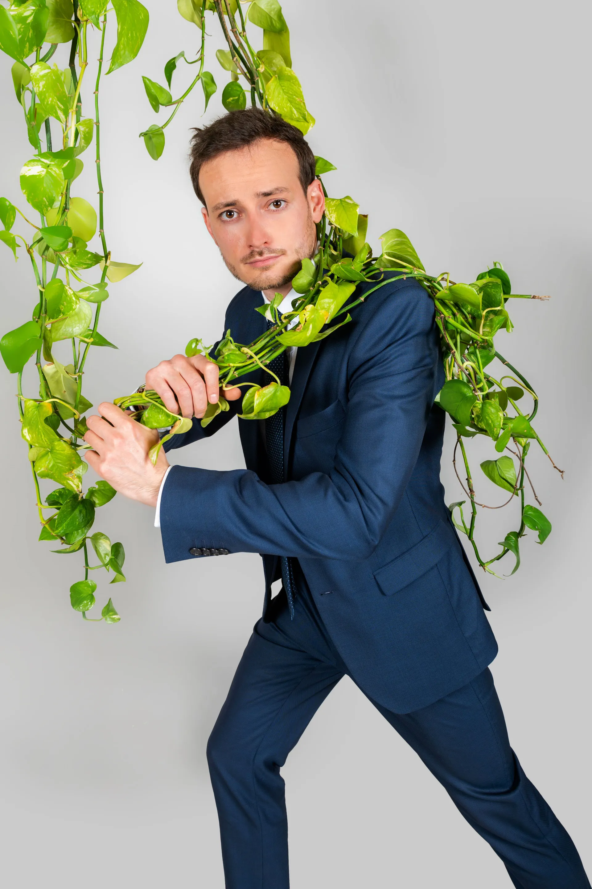 portrait studio d'un homme enlacé par une plante