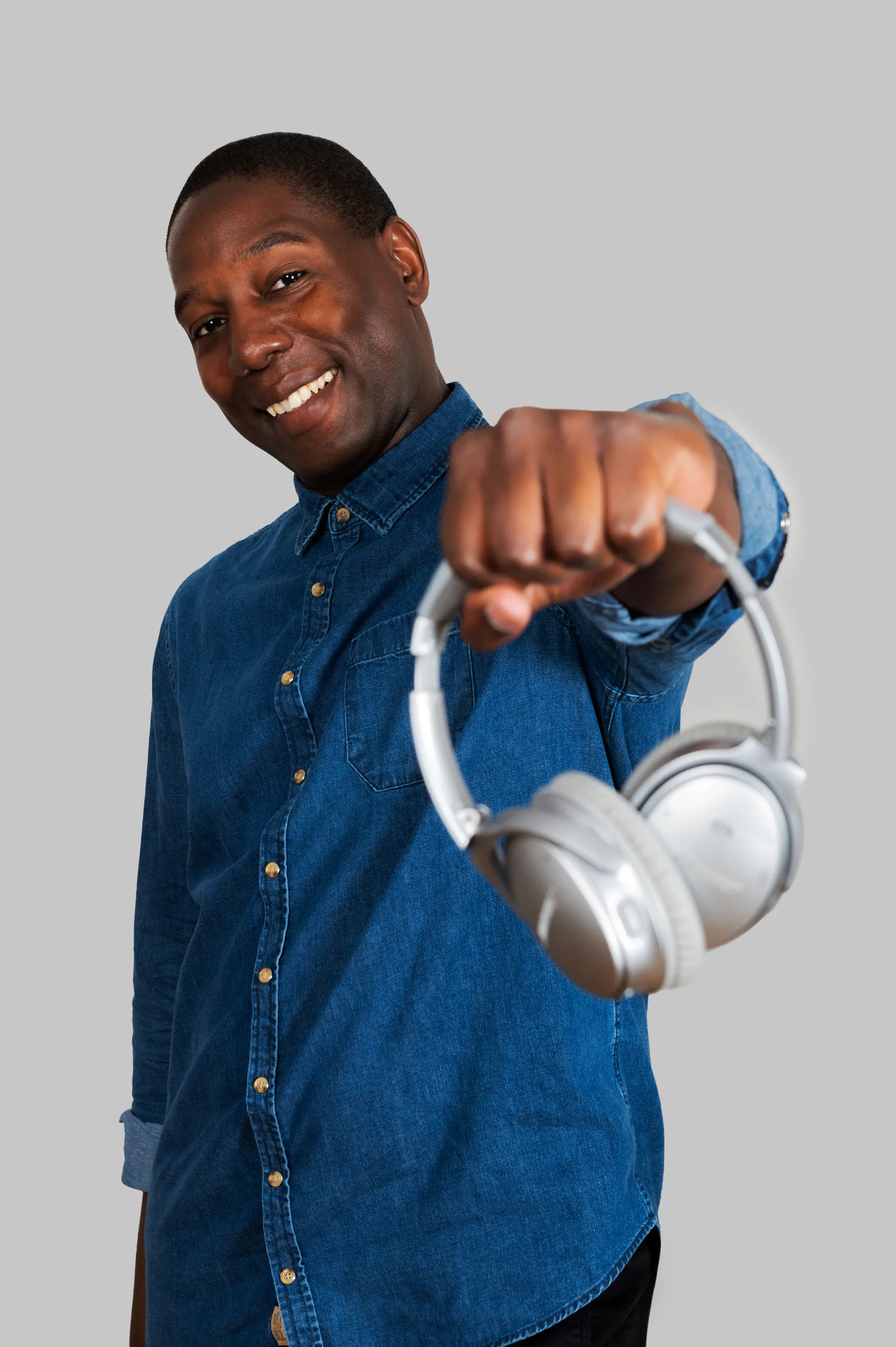 portrait studio d'un homme qui tient un casque audio sans fil