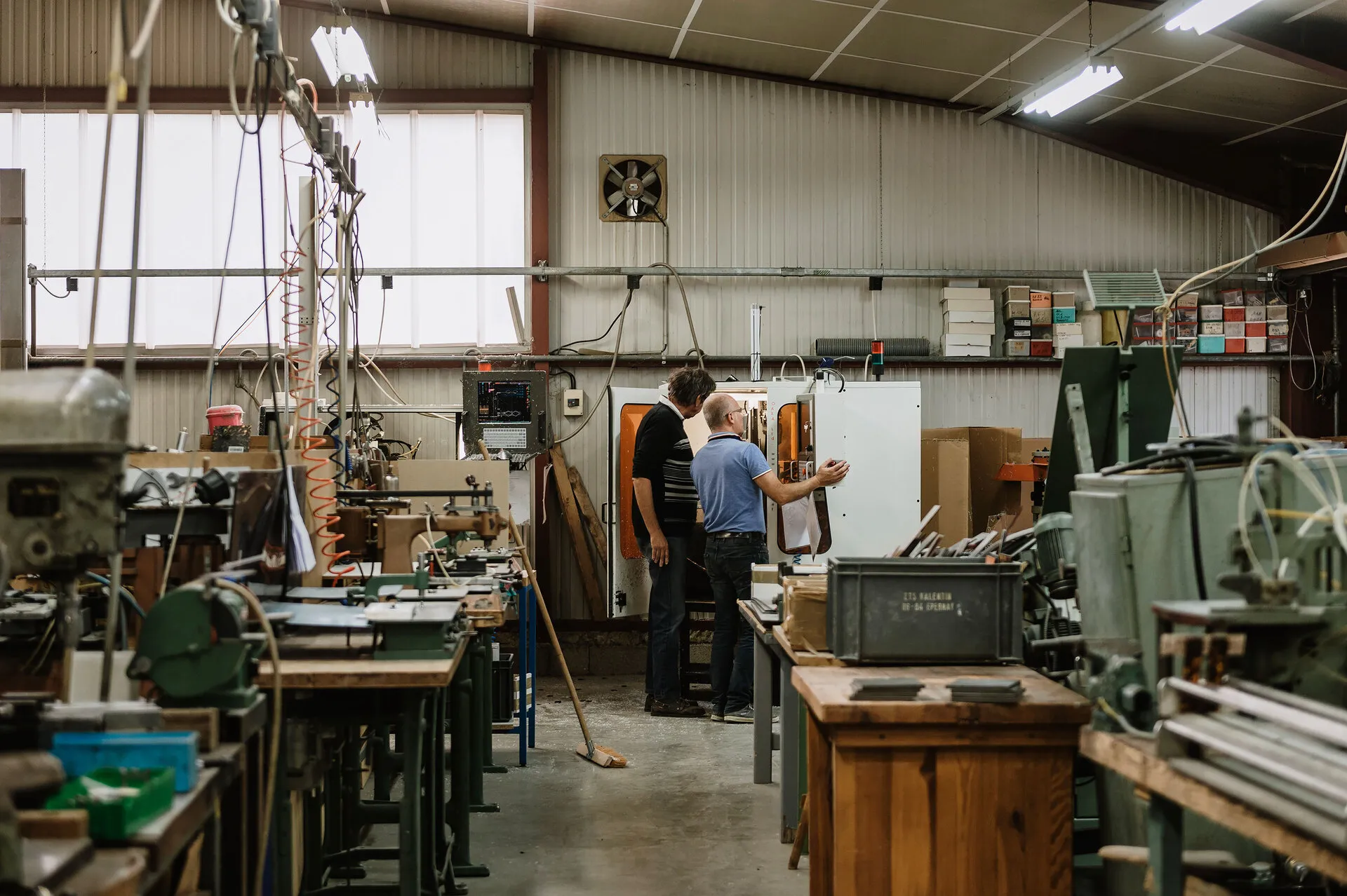 deux hommes au travail dans un atelier industriel