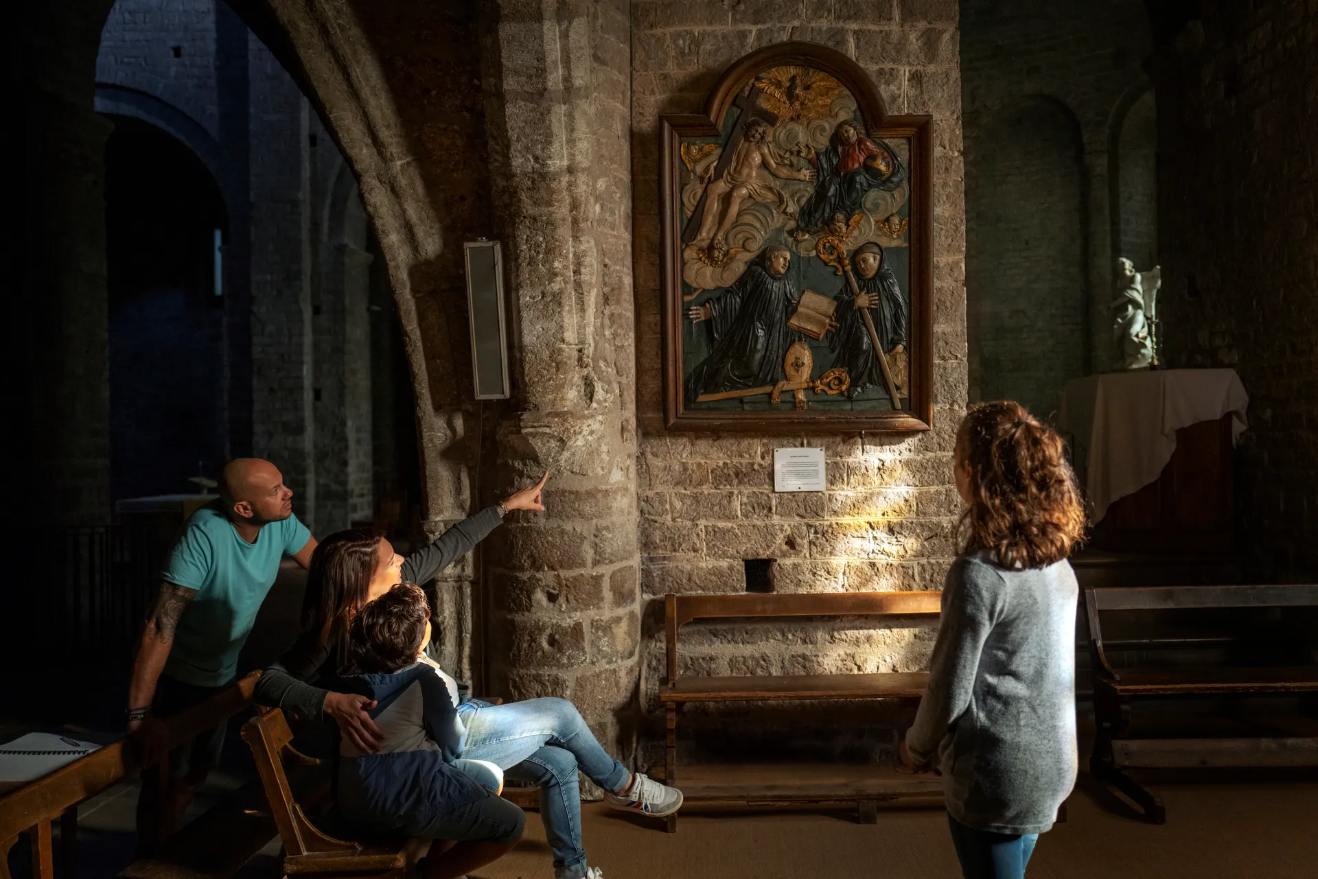 une famille visite l'église de St Guilhme le Désert